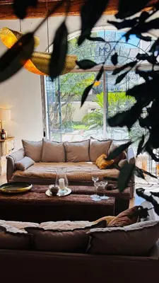 a living room with a couch and a table with wine glasses at Le Beldi, Mas de Village 1870 in Saint-Saturnin-lès-Avignon