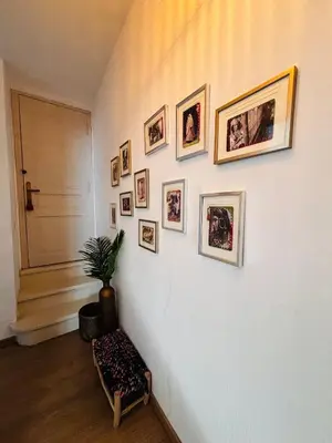 a hallway with a wall with pictures on it at Le Beldi, Mas de Village 1870 in Saint-Saturnin-lès-Avignon