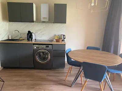 a kitchen with a table and a washing machine at SUNRISE - Golf de Pont Royal in Mallemort