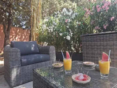a table with drinks and bowls of fruit on a patio at Logement indépendant avec Jacuzi pour 4ou 5 personnes, 2 chambres in Aureille