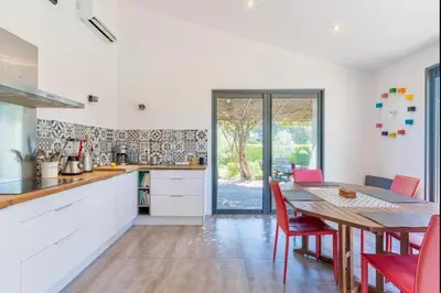a kitchen with a wooden table and red chairs at Villa Aix-en-Provence Pool and absolute calm in Aix-en-Provence