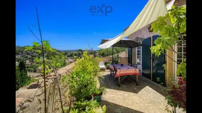 a patio with a table and an umbrella at Maison de famille en Provence in Rognes