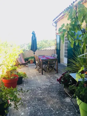 a patio with a table and chairs and plants at Maison de famille en Provence in Rognes