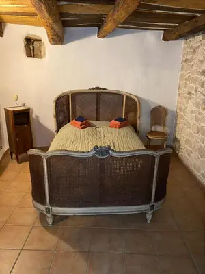 a bedroom with a wooden bed in a room at Room in Medieval Cereste in Céreste