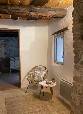 a chair and a table in a room with a window at Room in Medieval Cereste in Céreste