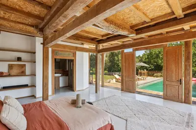 a bedroom with a large bed and a view of a pool at Big Modern Villa Ste Victoire 10min CityCenter Aix in Saint-Marc-Jaumegarde