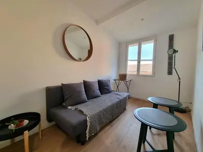 a living room with a couch and a mirror at Appartement climatisation centre historique in Aix-en-Provence