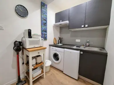 a kitchen with a washing machine and a microwave at Appartement climatisation centre historique in Aix-en-Provence