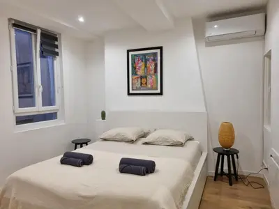two beds in a room with white walls at Appartement climatisation centre historique in Aix-en-Provence