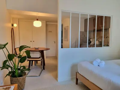 a bedroom with a table and a bed and a table and a plant at MAYU MAYU - cocon centre-ville climatisation in Aix-en-Provence