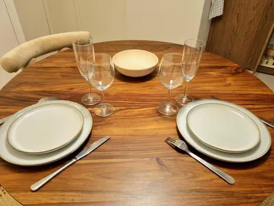 a wooden table with plates and wine glasses on it at MAYU MAYU - cocon centre-ville climatisation in Aix-en-Provence