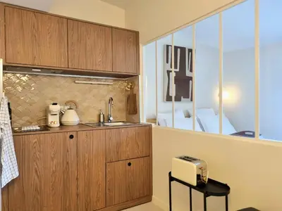 a kitchen with wooden cabinets and a sink at MAYU MAYU - cocon centre-ville climatisation in Aix-en-Provence