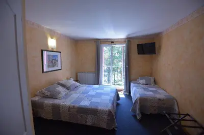 a bedroom with two beds and a window at Hôtel PRATO PLAGE in Pernes-les-Fontaines