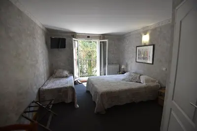 a bedroom with two beds and a window at Hôtel PRATO PLAGE in Pernes-les-Fontaines