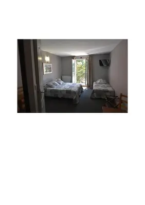 a room with two beds and a mirror at Hôtel PRATO PLAGE in Pernes-les-Fontaines