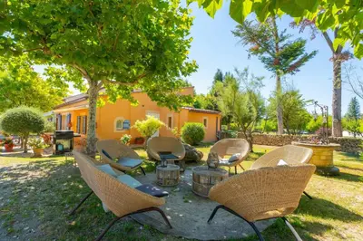 a group of chairs and a table in a yard at Le Mas des lys - Guest houses au coeur de la Provence dans un parc paysagé avec piscine, sauna et boulodrome in Grans