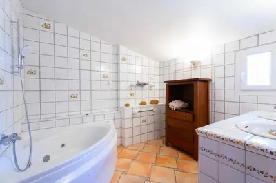 a white bathroom with a tub and a sink at Le Mas des lys - Guest houses au coeur de la Provence dans un parc paysagé avec piscine, sauna et boulodrome in Grans