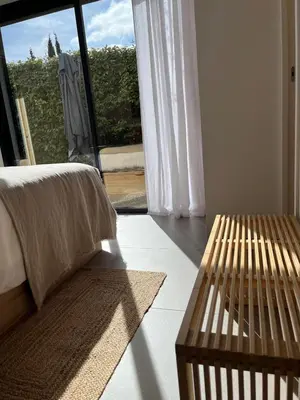 a bedroom with a bed and a table and a window at La Réserve Villa in Aix-en-Provence