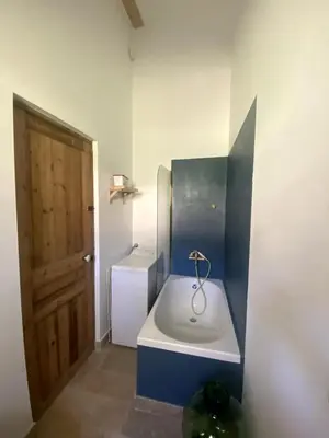a small bathroom with a sink and a door at Villa Augustine in Ventabren