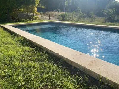 a swimming pool in the middle of the grass at Villa Augustine in Ventabren