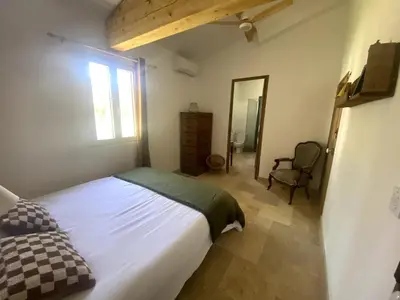 a bedroom with a bed and a window and a chair at Villa Augustine in Ventabren