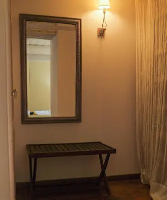 a living room with a table and shelves on the wall at Montjoia in LʼIsle-sur-la-Sorgue
