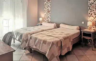 a bedroom with two beds and two tables and a window at Nice Home In Carpentras in Carpentras
