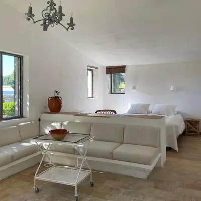 a living room with a couch and a bed at La Grande Bastide in Vaugines