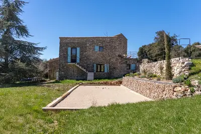 a stone house with a basketball court in front of it at Evasion Luberon in Murs