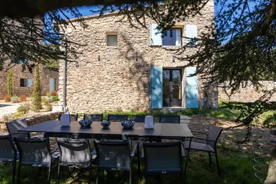 a table and chairs in front of a stone building at Evasion Luberon in Murs