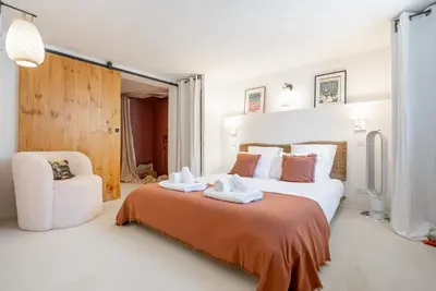 a bedroom with a large bed and a chair at Evasion Luberon in Murs