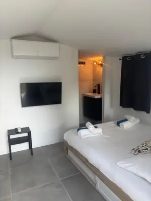 a hotel room with two beds and a tv at Universo private pool and large garden in Pernes-les-Fontaines