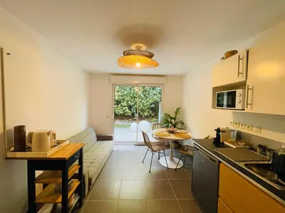 a kitchen with a couch and a table in a room at Apartment with beautiful terrace in LʼIsle-sur-la-Sorgue