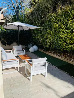 a patio with two chairs and a table and an umbrella at Apartment with beautiful terrace in LʼIsle-sur-la-Sorgue