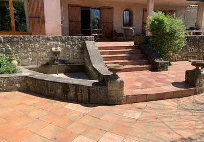 a fountain in the middle of a patio at Villa CHATEAU SAINTE BARBE in Loriol-du-Comtat