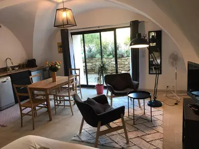 a kitchen and living room with a table and chairs at Studio indépendant avec piscine proche Lourmarin in Lourmarin