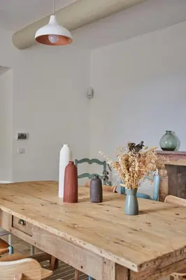 a wooden table in a dining room with vases on it at Bastide entièrement rénovée au coeur de Goult in Goult