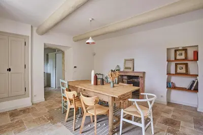 a dining room with a wooden table and chairs at Bastide entièrement rénovée au coeur de Goult in Goult
