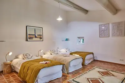 three beds in a room with white walls at Bastide entièrement rénovée au coeur de Goult in Goult