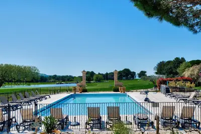 a swimming pool with chairs and a golf course at Résidence Hôtel du Golf de Pont Royal - maeva Home - Appartement avec jardin 2 pièces 4 personnes - Prestige - super Home MAE-8891 in Mallemort