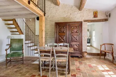a dining room with a wooden table and chairs at Maison de James in Murs