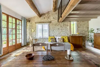 a bedroom with a bed and a table and windows at Maison de James in Murs