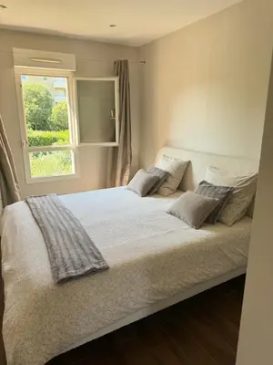 a bedroom with a large white bed with a window at Évasion Provençale in Aix-en-Provence