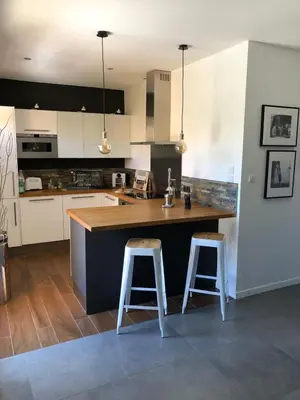 a kitchen with a counter and two bar stools at Évasion Provençale in Aix-en-Provence