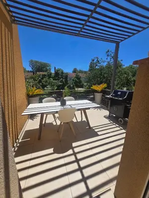 a table and chairs on a patio with a grill at Évasion Provençale in Aix-en-Provence
