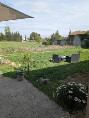 a yard with two chairs and a field with a building at Gîte The Butterfly - 1 bedroom and mezzanine in Monteux