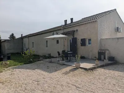 a patio with a table and an umbrella in front of a building at Gîte The Butterfly - 1 bedroom and mezzanine in Monteux