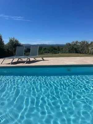 two chairs sitting next to a swimming pool at Villa avec vue sur le pilon du roi in Aix-en-Provence