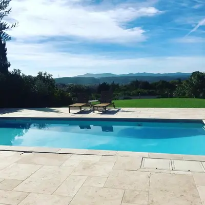 a swimming pool with a bench and a table at Villa avec vue sur le pilon du roi in Aix-en-Provence