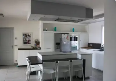 a kitchen with a black table and white appliances at Villa avec vue sur le pilon du roi in Aix-en-Provence